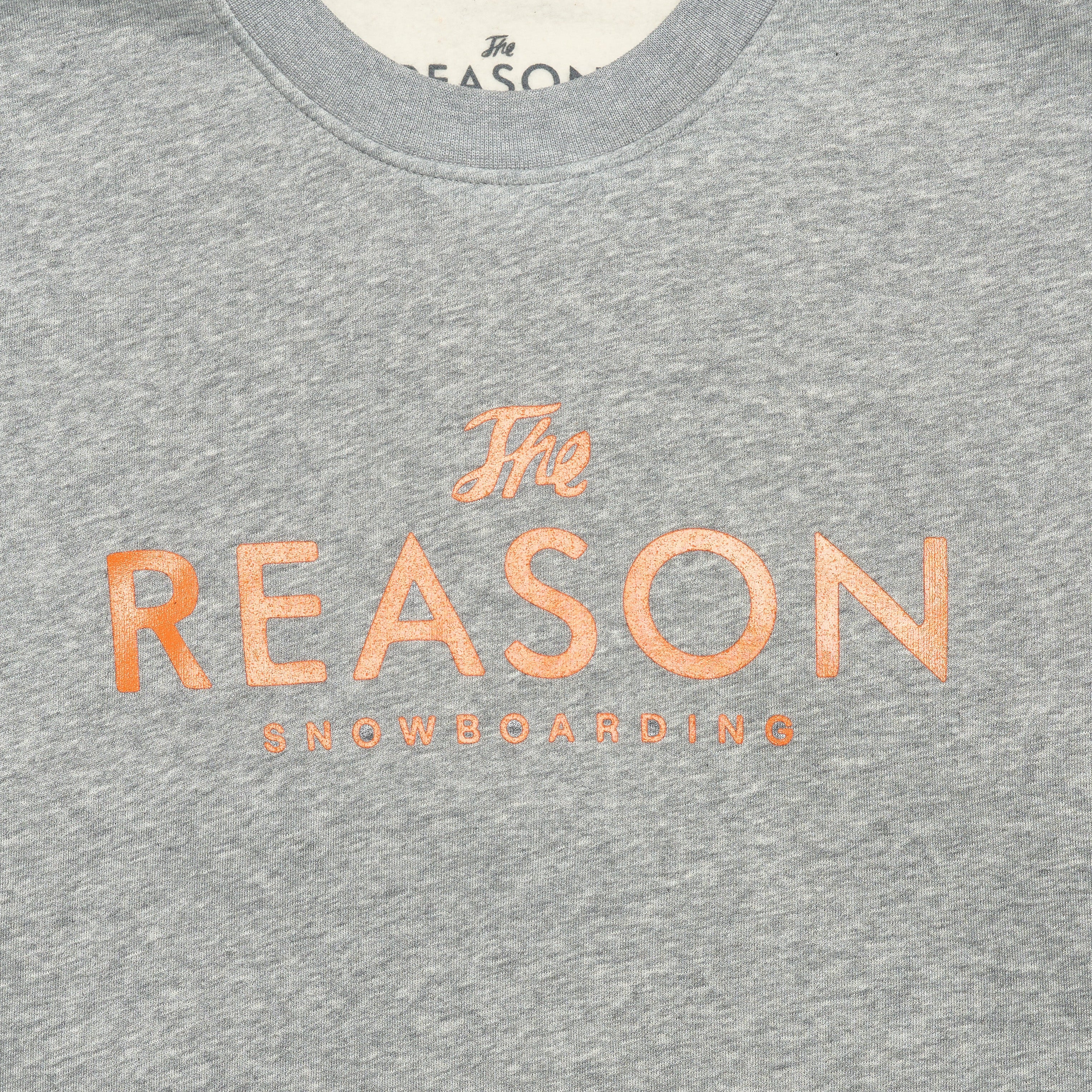 Grey sweatshirt with 'The Reason Snowboarding' text on a white background