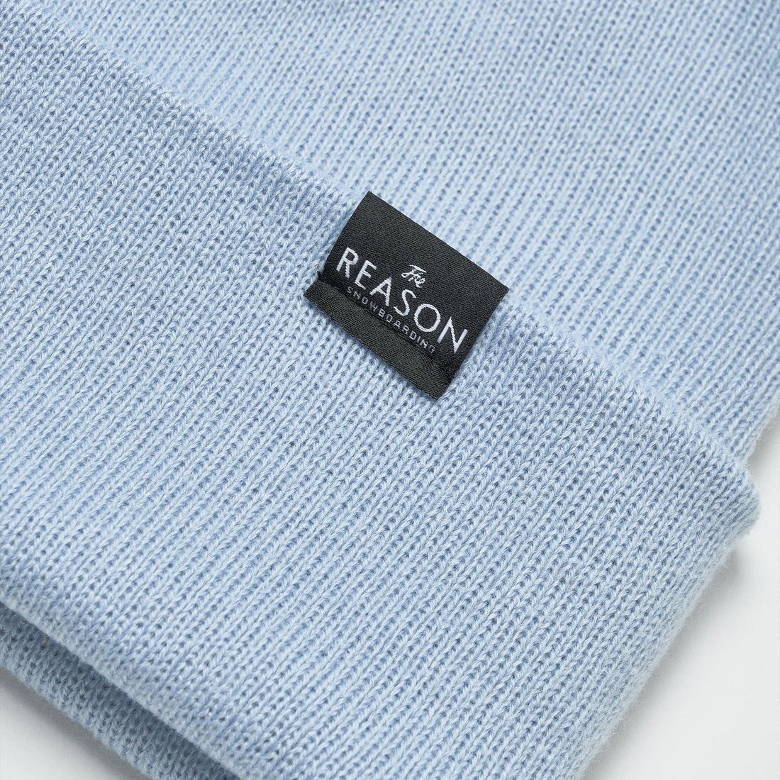 Light blue knit sweater with a black label on a white background