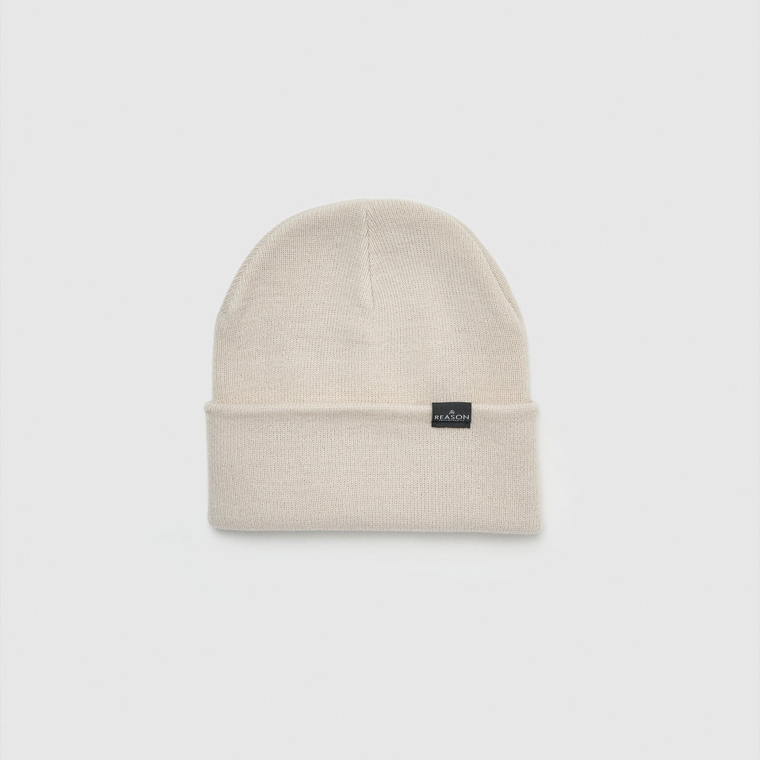 Beige beanie with a small black label on a light gray background