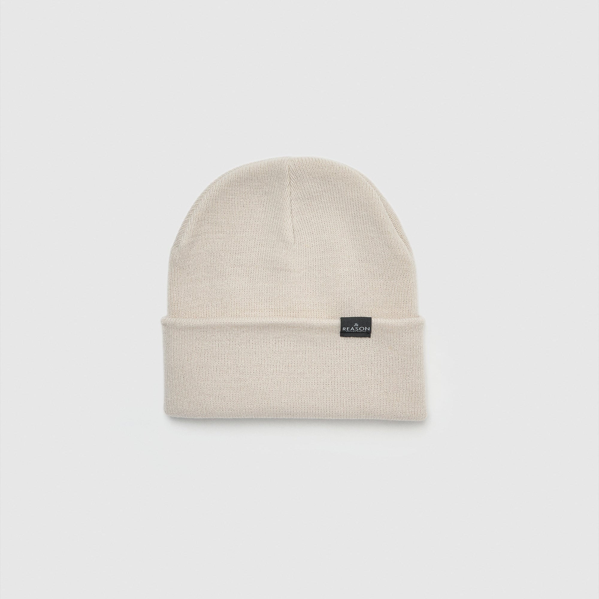 Beige beanie with a small black label on a light gray background