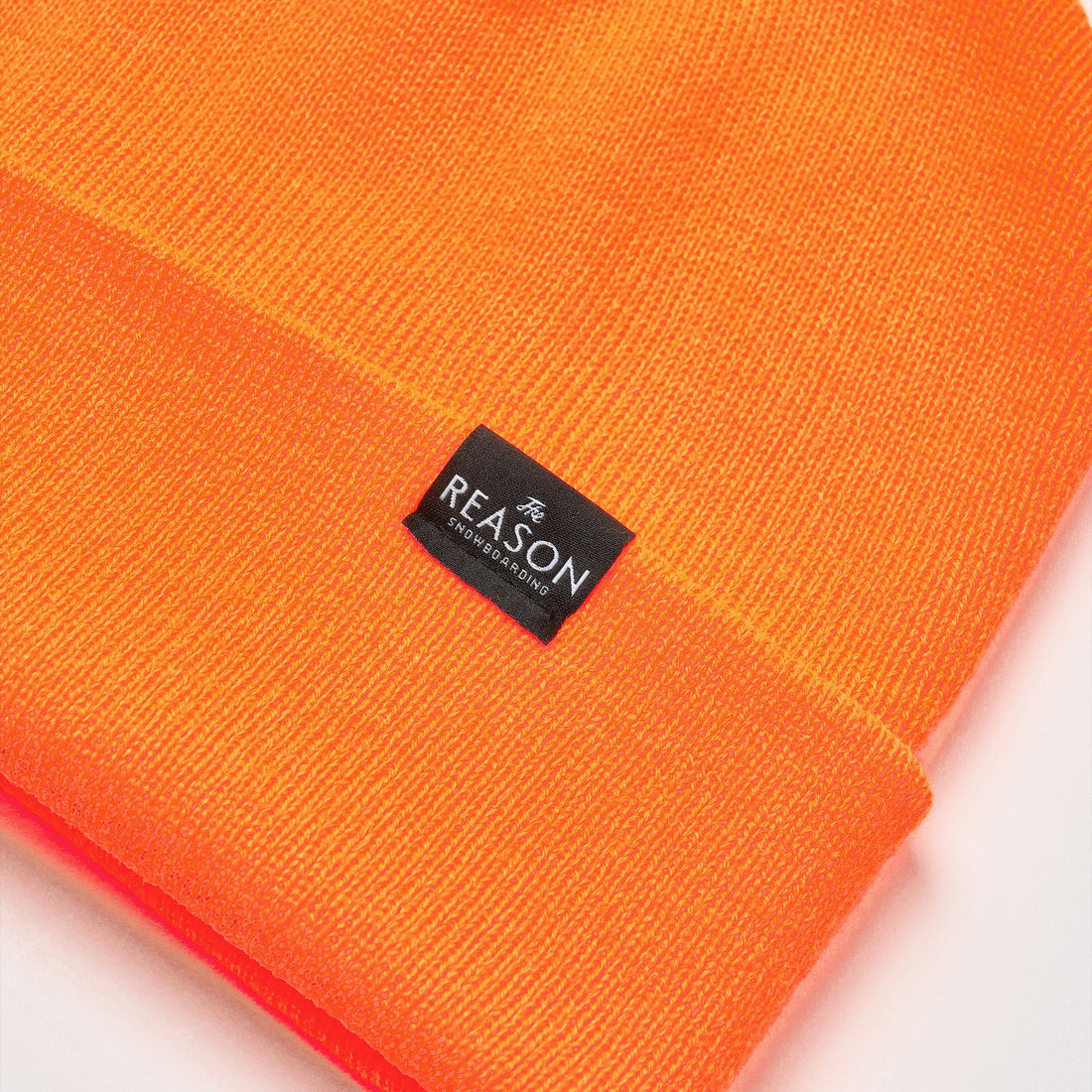 Orange beanie with a black label on a white background